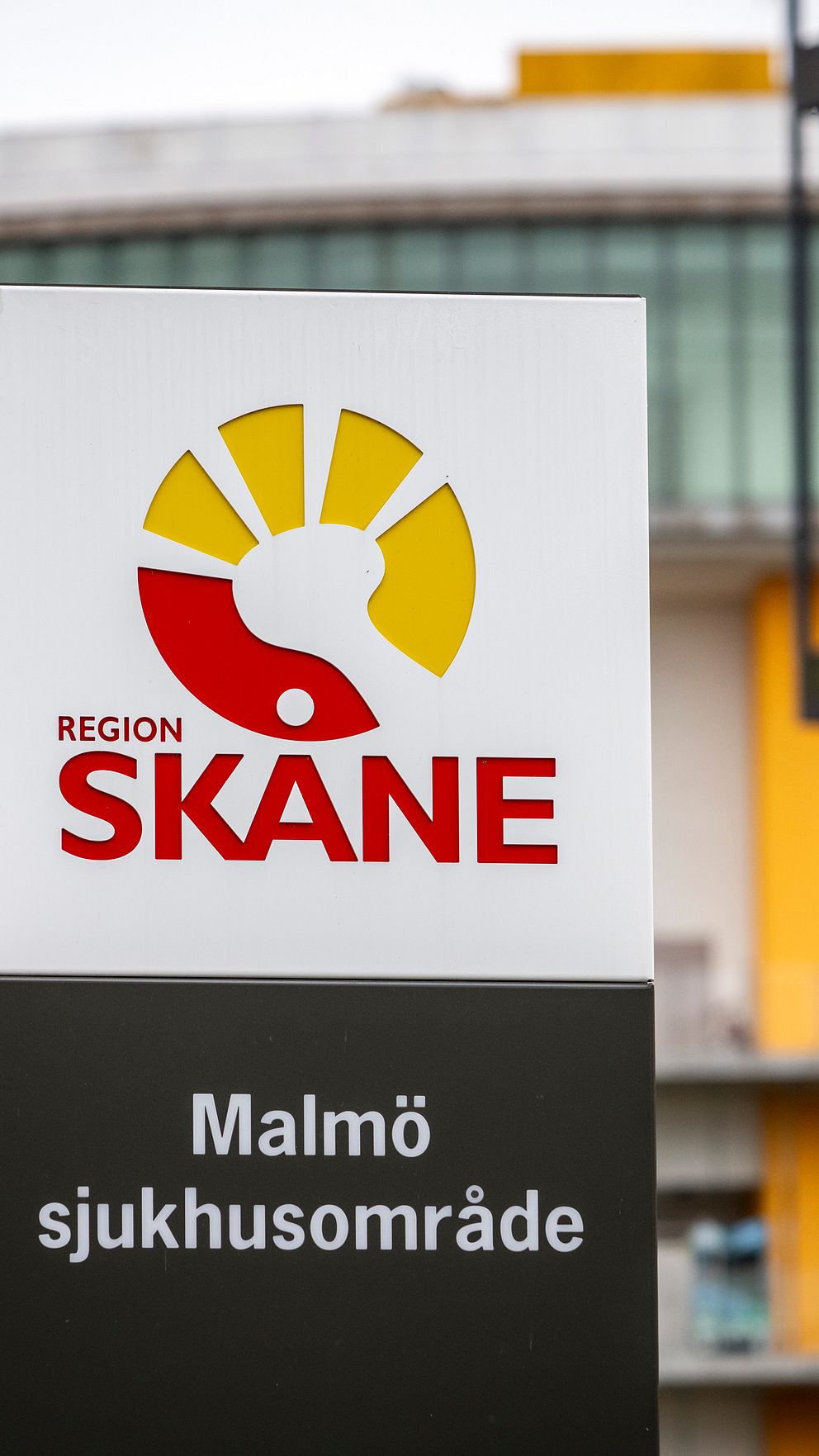Skylt med Region Skåne och Malmö sjukhusområde framför sjukhusbyggnad.