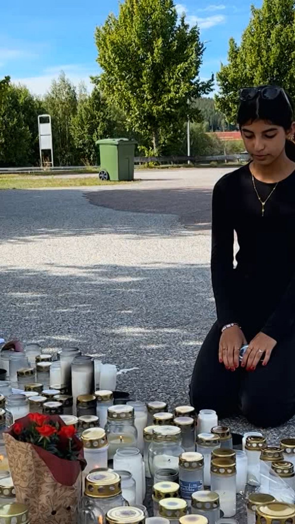 Waran Mohammed Pwan sitter vid ljus och blommor på skolgården