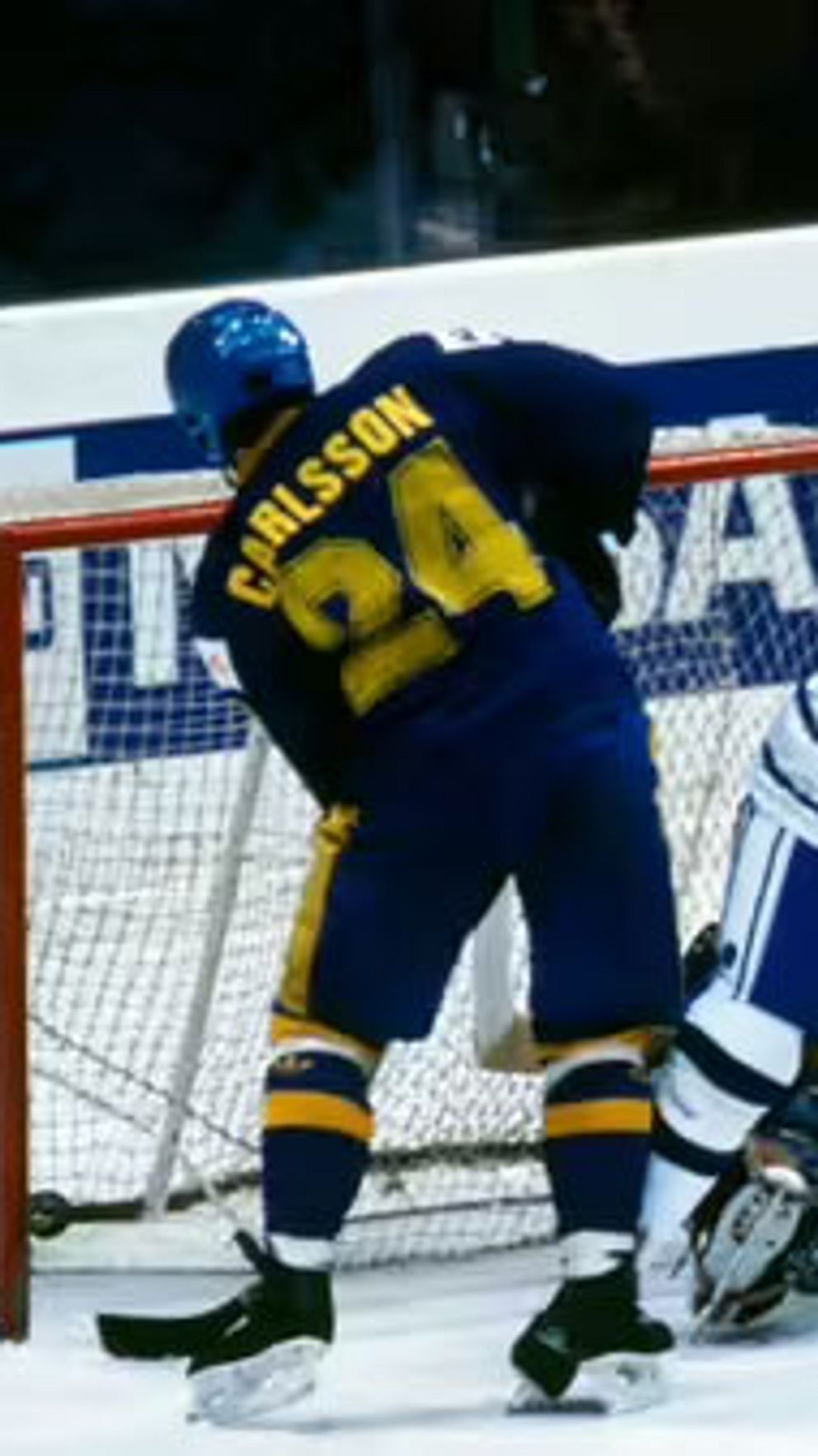 Ishockeymatch mellan Sverige och Finland vid målbur, spelare slåss om pucken.