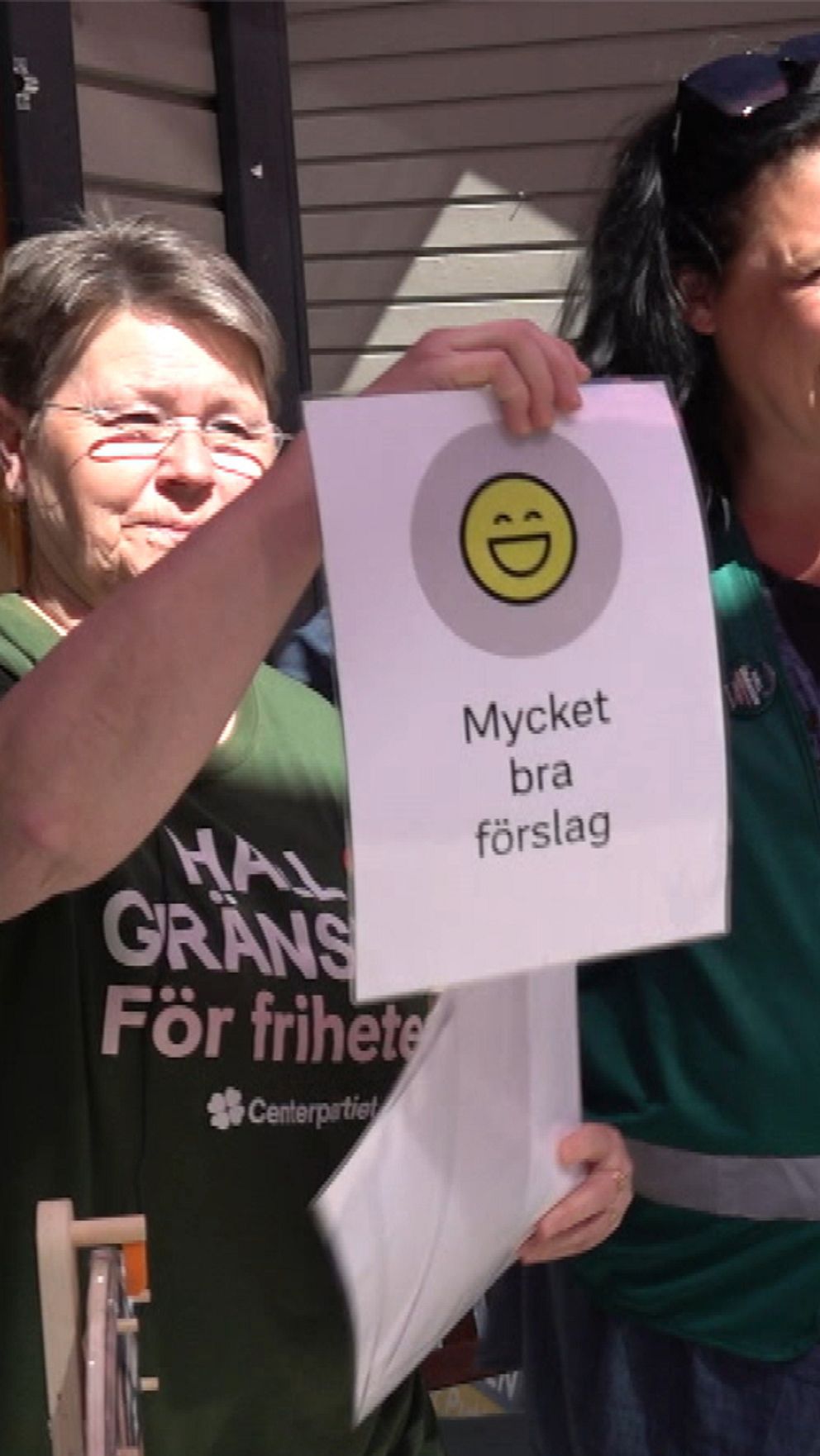Två politiker från Centerpartiet och en från Sverigedemokraterna. De håller upp varsin skylt.