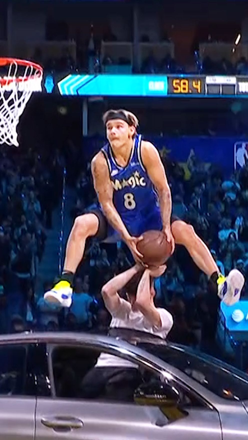 En delad bild från en basketmatch. Till vänster utför en basketspelare i Orlando Magic-uniform en spektakulär dunk över en bil medan publiken ser på. Till höger står samma spelare med händerna på huvudet, klädd i samma uniform.