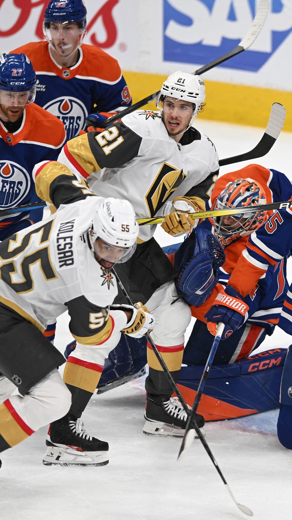 Hockeyspelare från Vegas och Edmonton kämpar framför mål under en NHL-match.