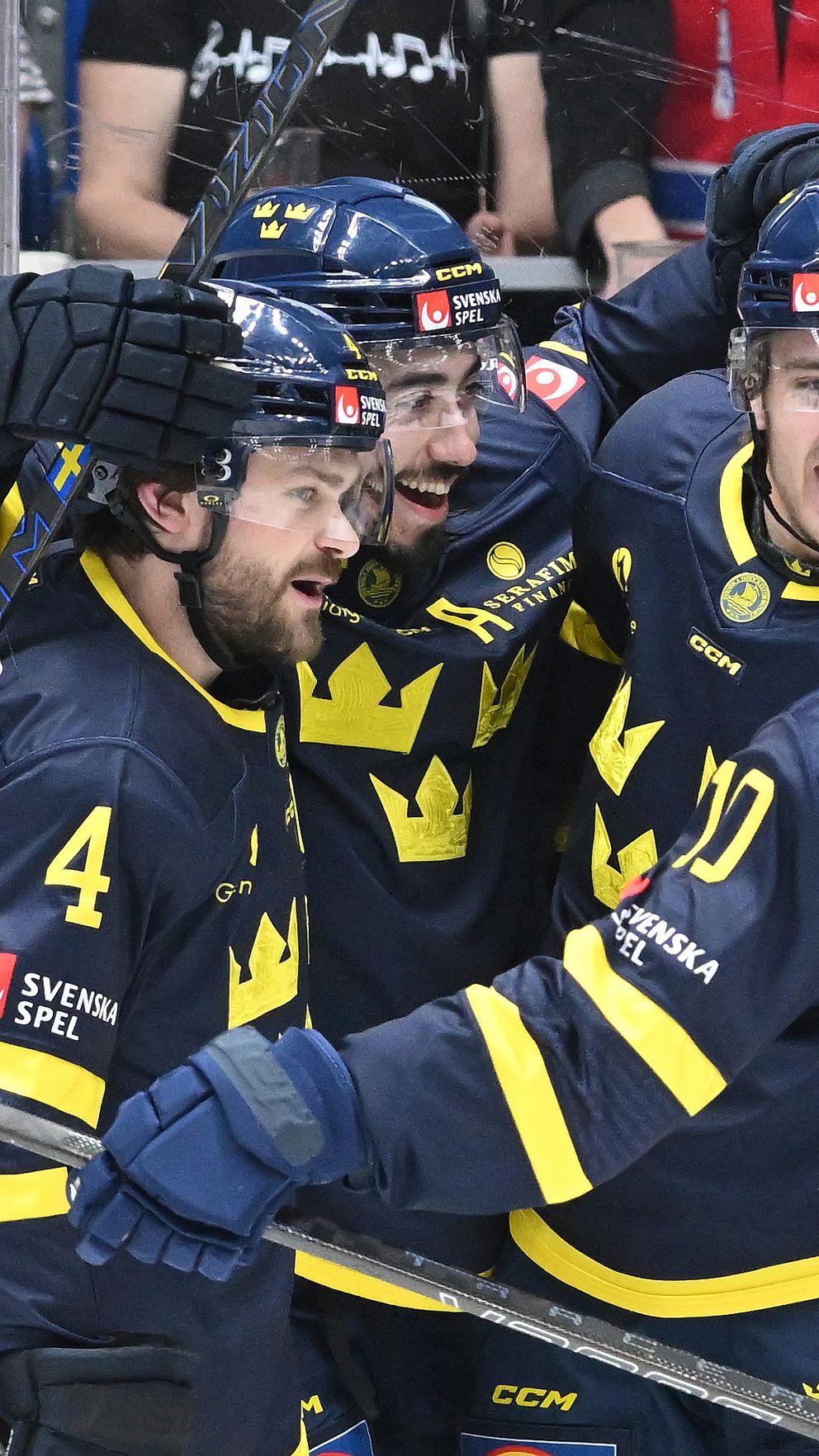 Tre Kronor-spelare firar mål tillsammans under en ishockeymatch.