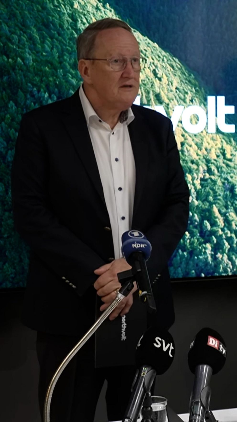 Northvolts interimsordförande Tom Johnstone under preskonferensen, framför honom är flera mikrofoner.