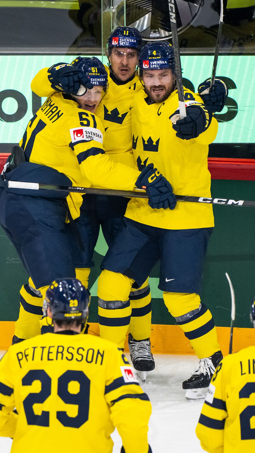 Svenska ishockeyspelare firar mål under en landskamp. Pettersson och Lindholm syns i förgrunden.