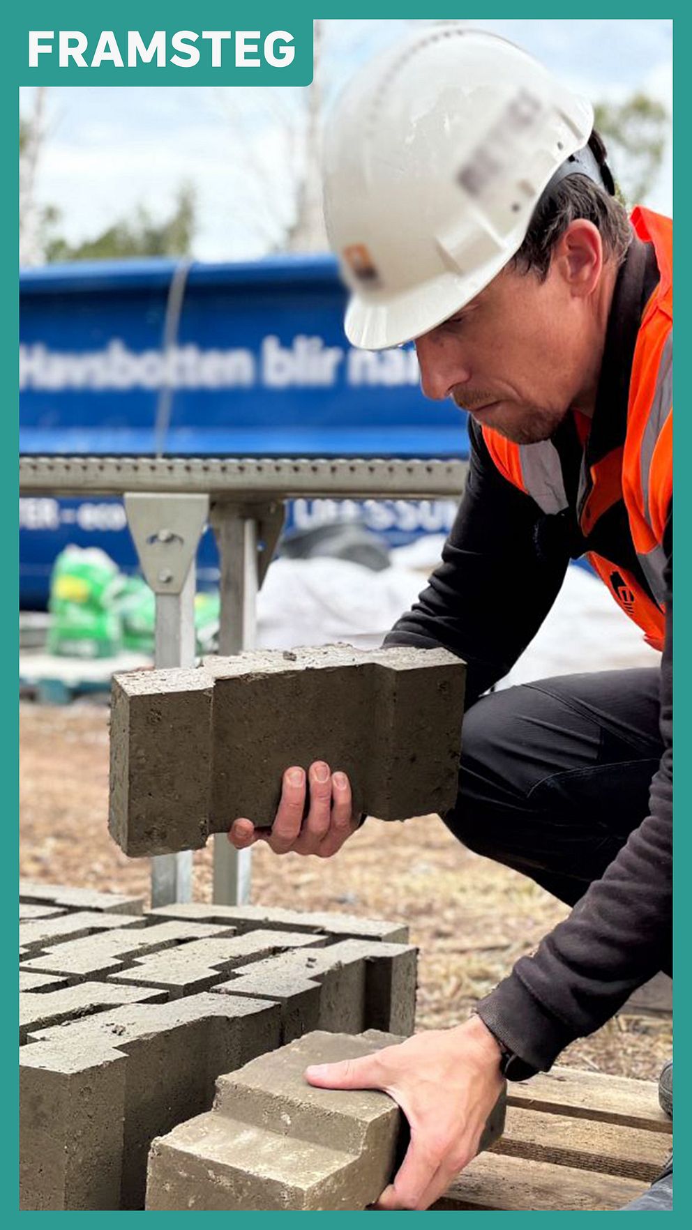 Person i skyddsutrustning staplar byggklossar gjorda av pressat havssediment.