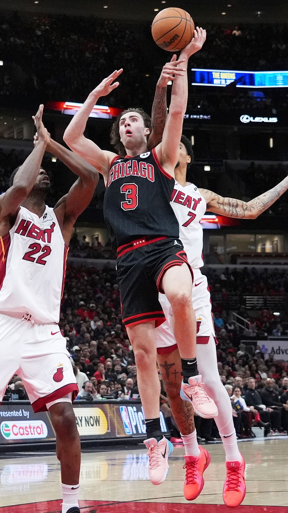 Basketbollspelare från Miami Heat och Chicago Bulls under match. Spelaren i svart skjuter.