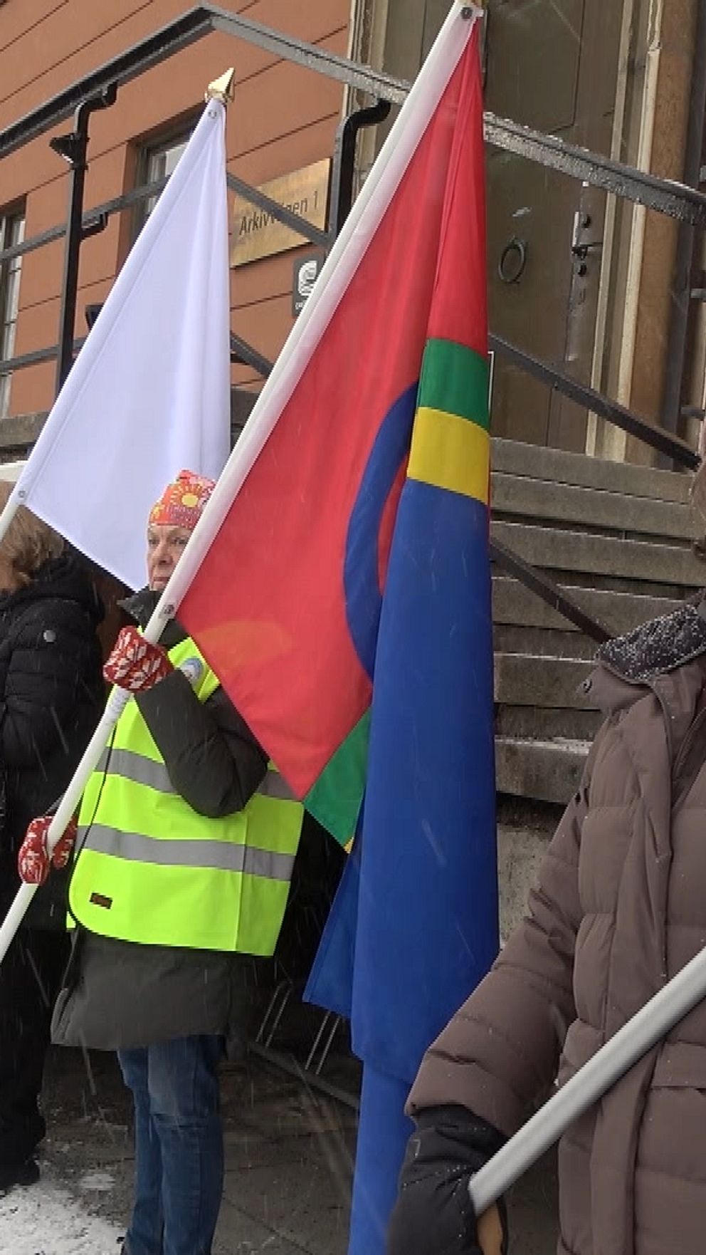 Personer demonstrerar utanför Riksarkivet med samiska och andra flaggor.