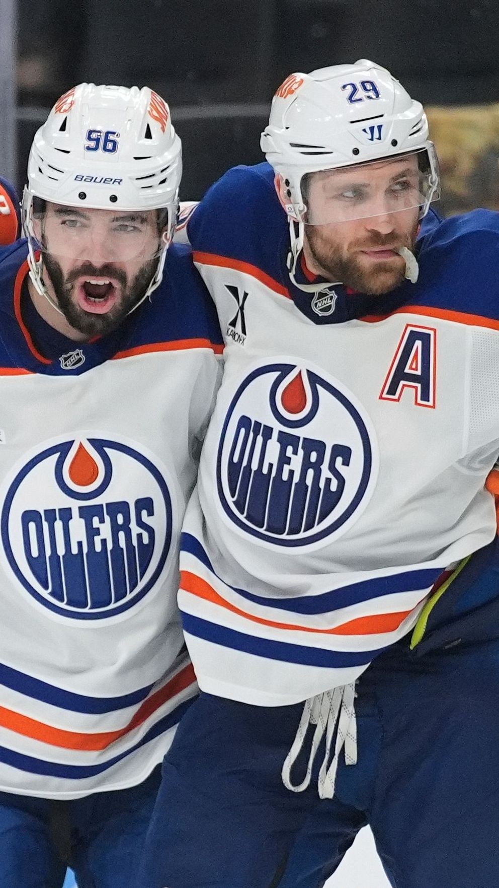 Två Edmonton Oilers-spelare firar tillsammans på isen under en ishockeymatch.