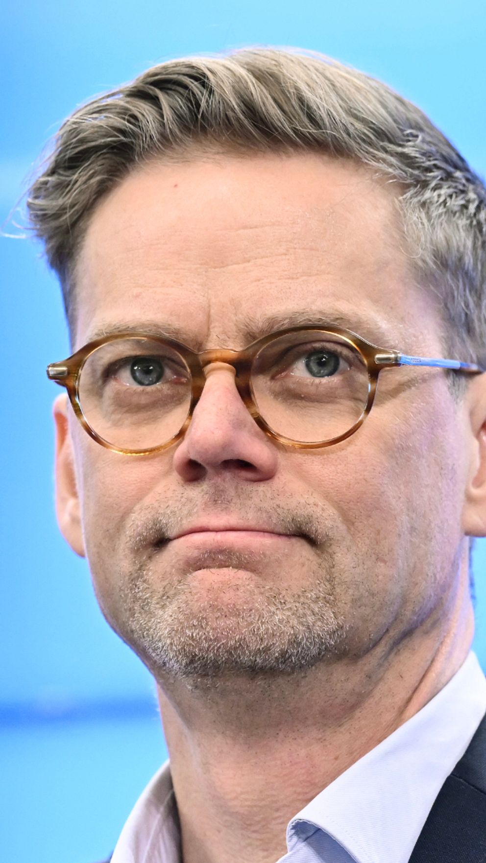 Jakob Olofsgård (L), kort blont hår, skäggstubb och glasögon.
