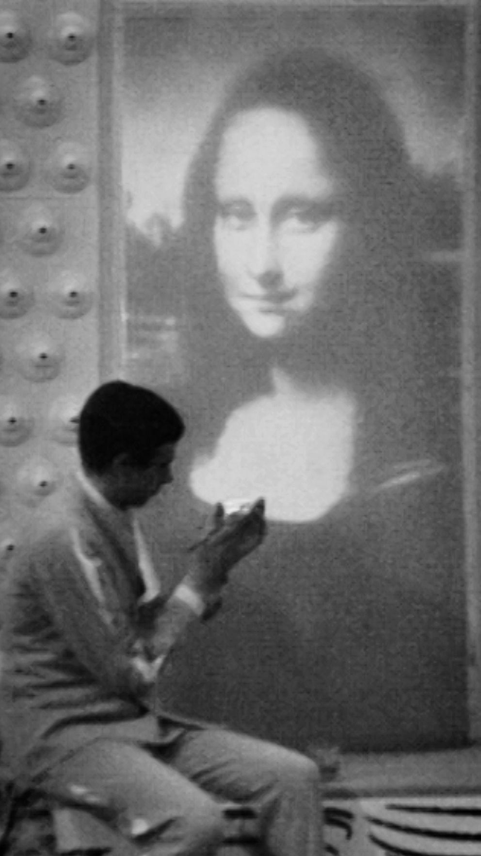 Man målar framför en bild på Mona Lisa.
