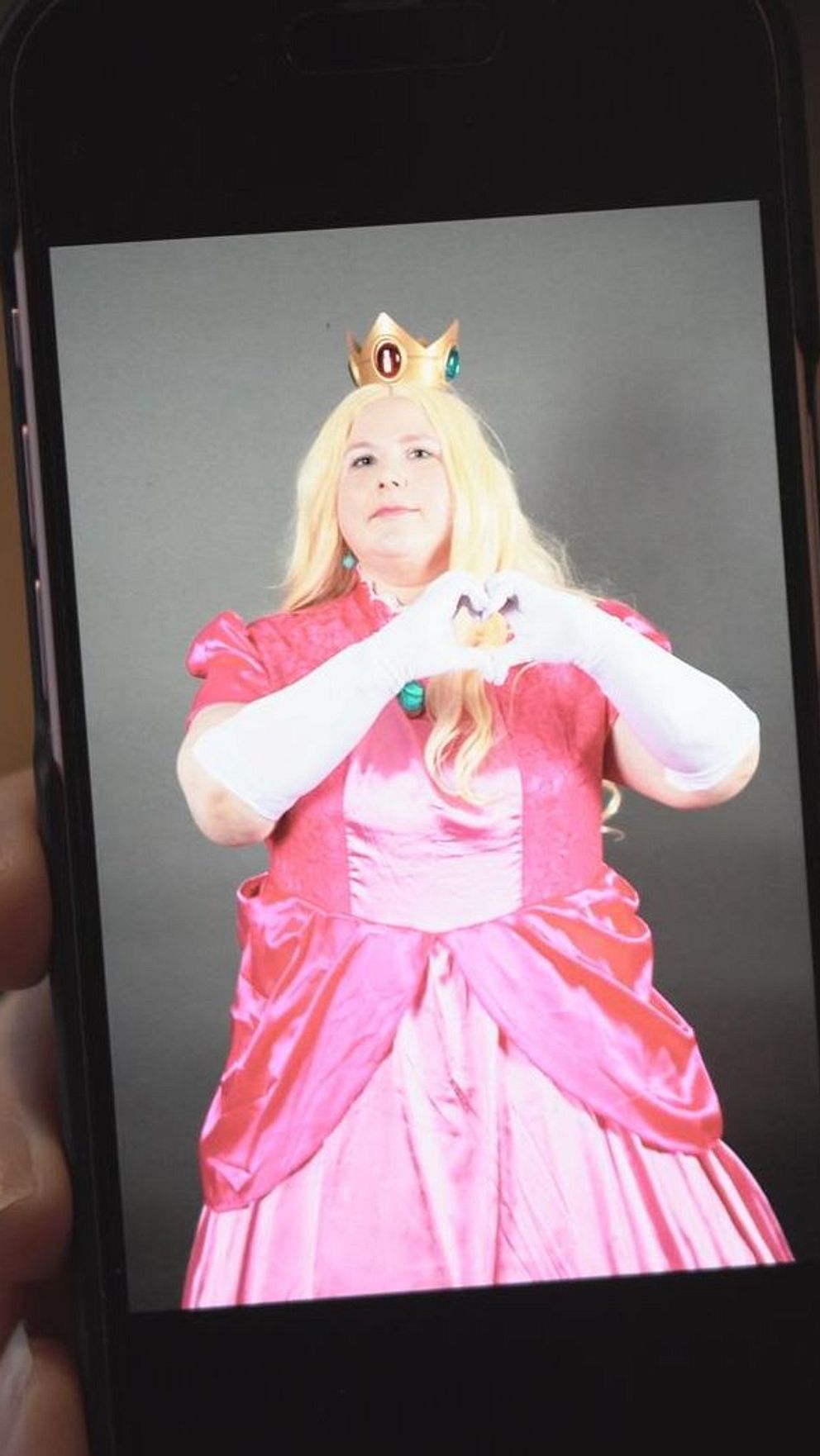 Person i prinsesskostym på mobilskärm.