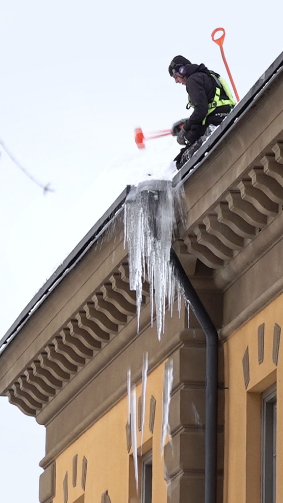 En takskottare slår ner istappar i Östersund.