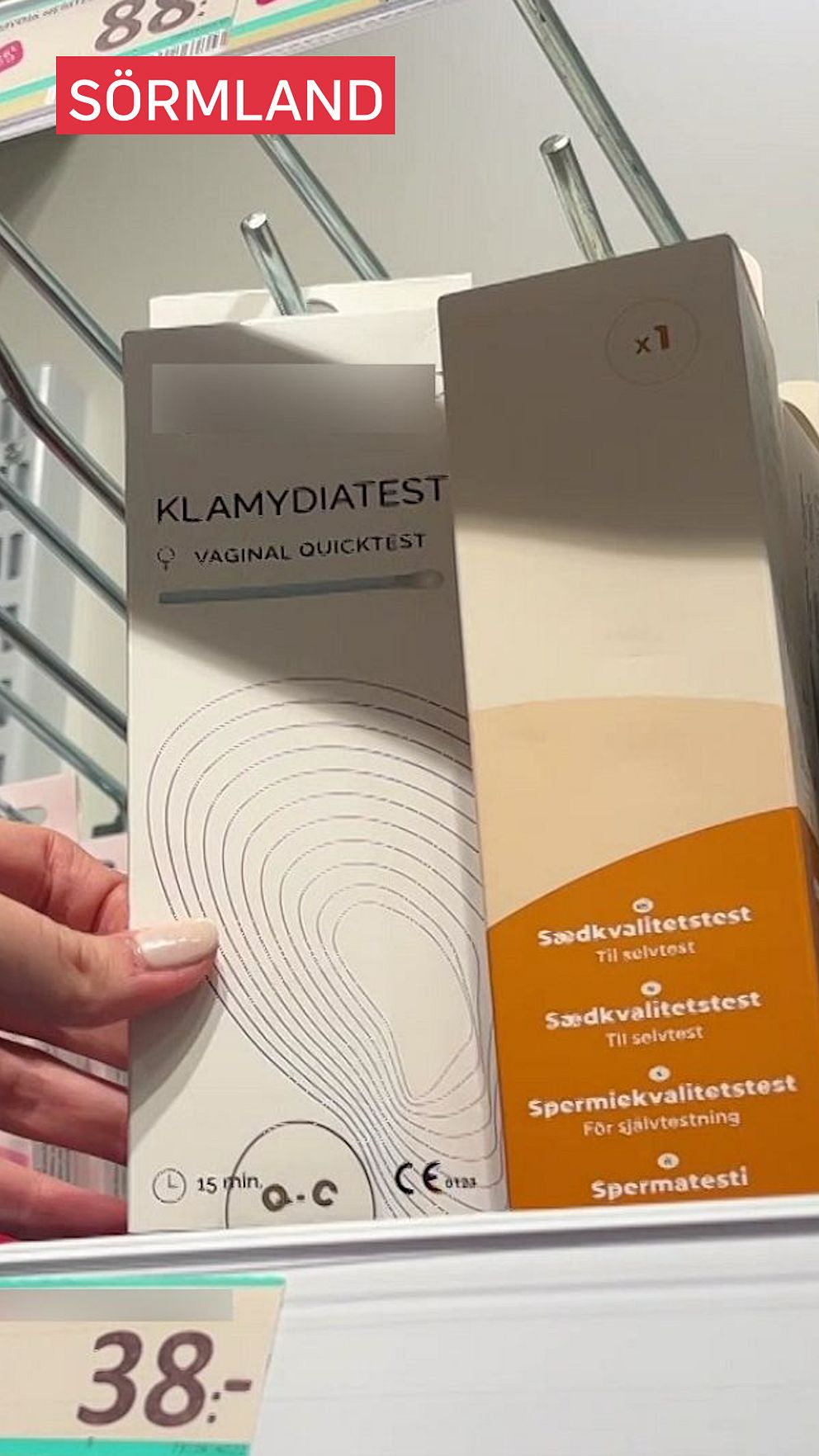 Hand håller paket med klamydiatest i affär.