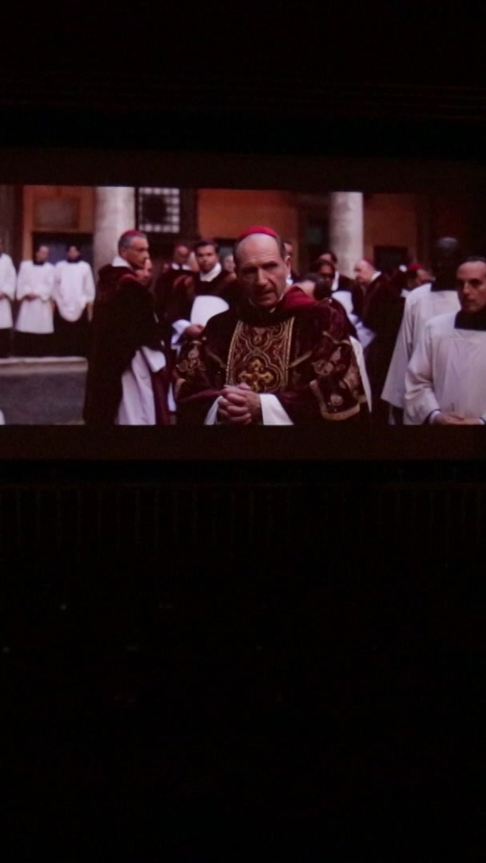En film spelas upp på en bioduk i ett mörkt rum.