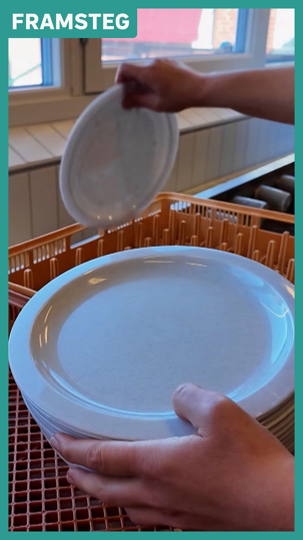 Skolkökspersonal staplar plasttallrikar i skolkökets diskmaskin.