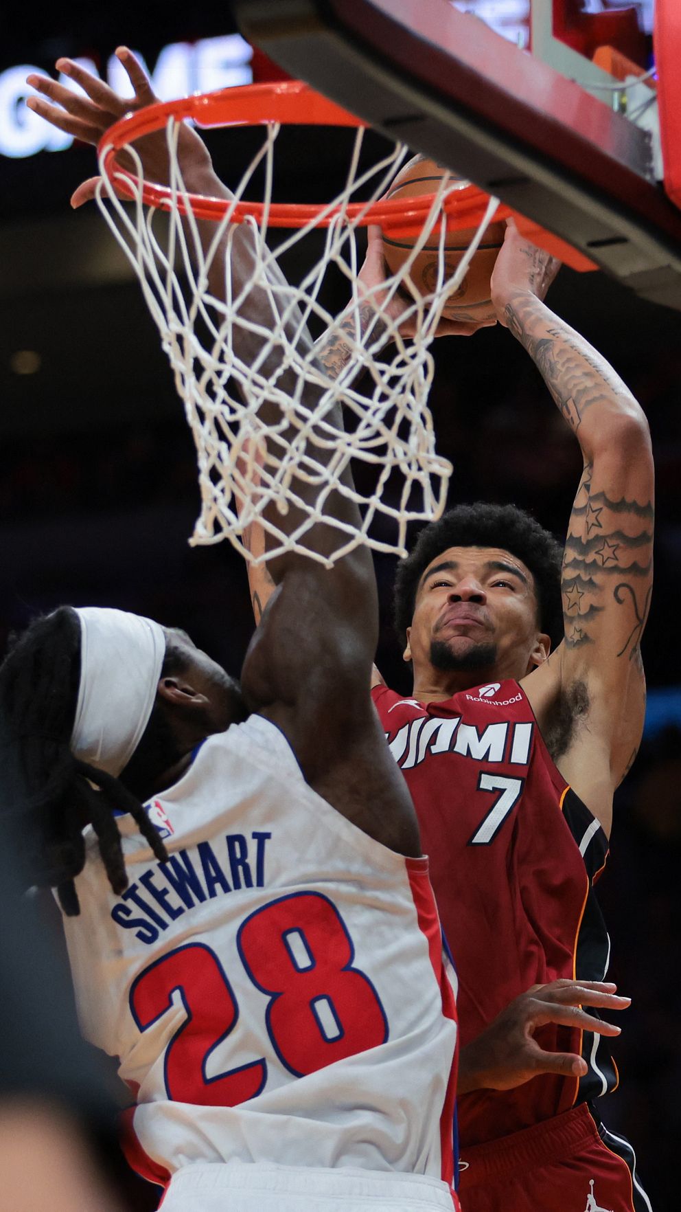 En basketspelare från Miami dunkar över motståndare från Detroit Pistons under en match.