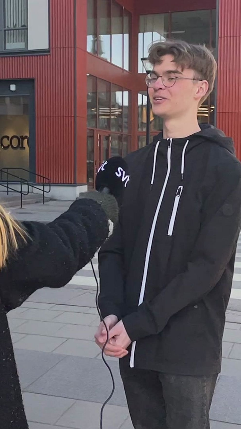 SVT-reporter intervjuar två killar på en stadsgata.