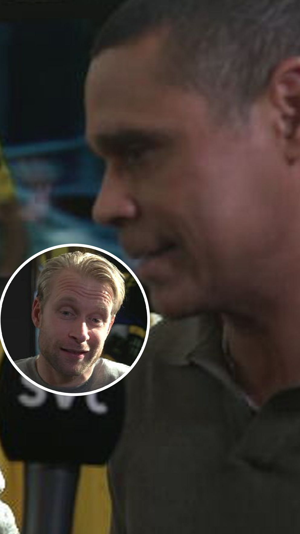 Svart mikrofon med SVT-logotyp riktas mot en oskarpa person i en skjorta.