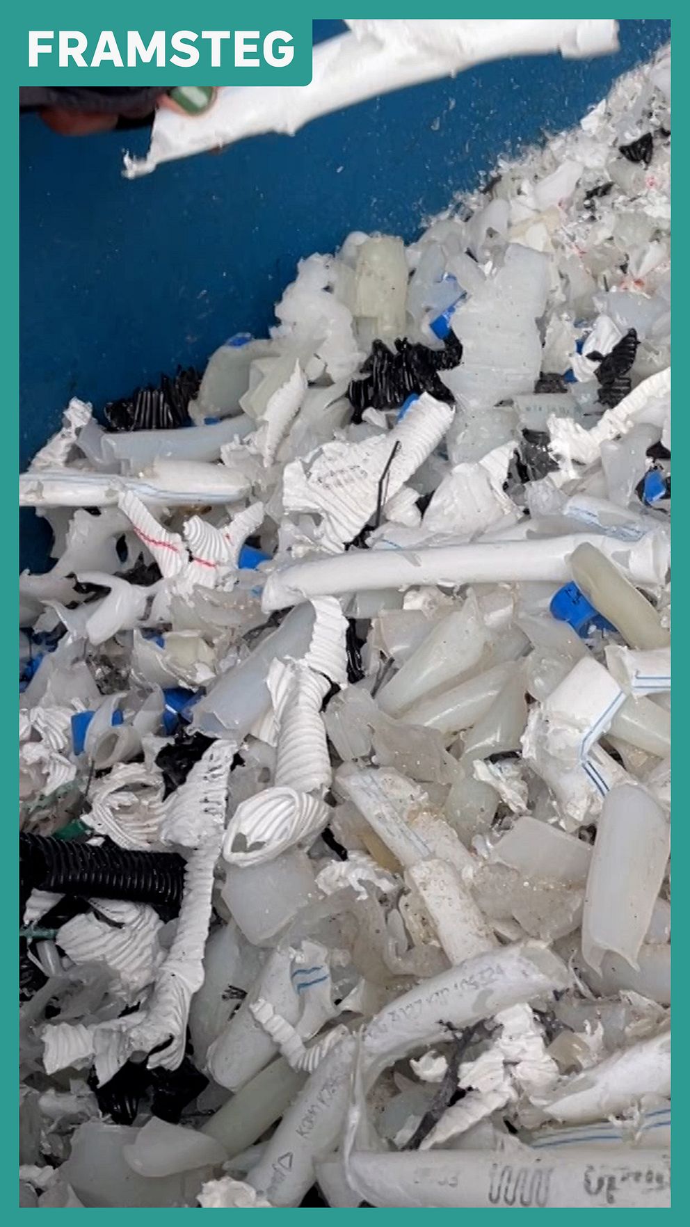 Krossade plastföremål i blå behållare med texten ”Framsteg” ovanpå.