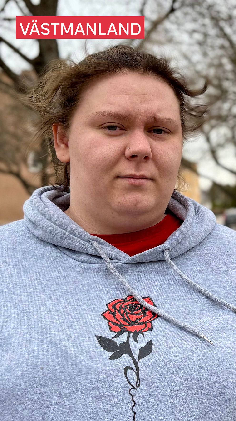 Lia, som under större delen av sitt liv självskadat med bland annat paracetamol, står i grå hoodie med ros-design.