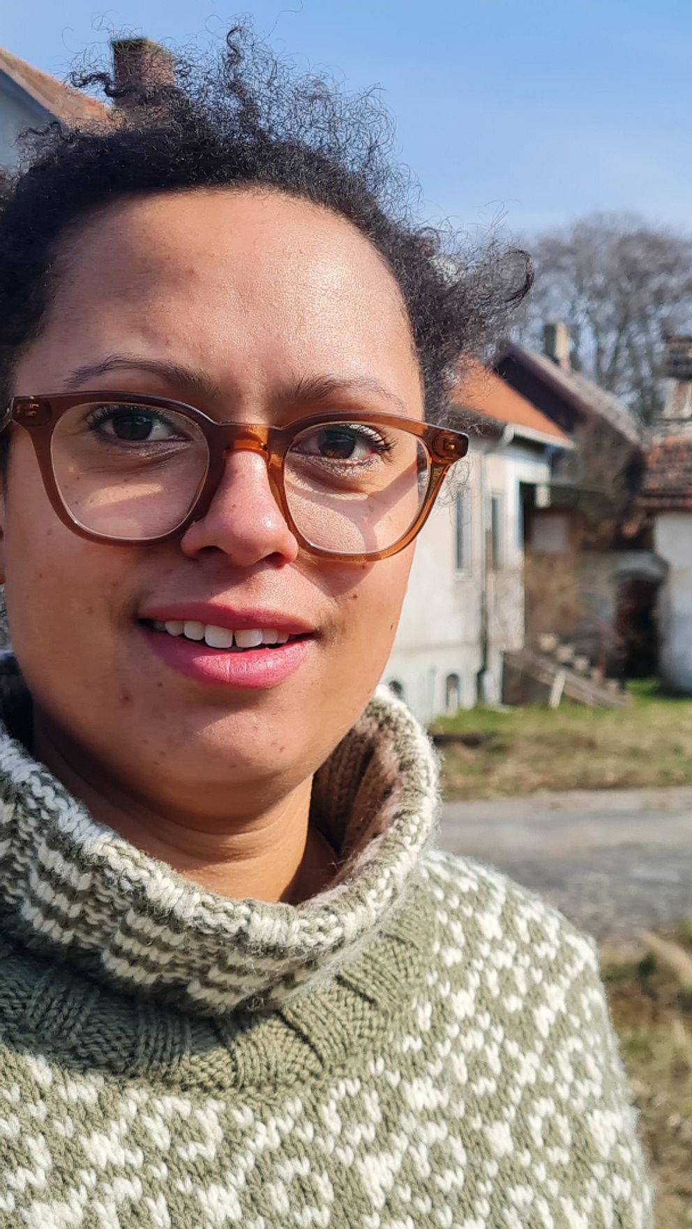Melissa Nyström framför ett ödehus på den skånska landsbygden.