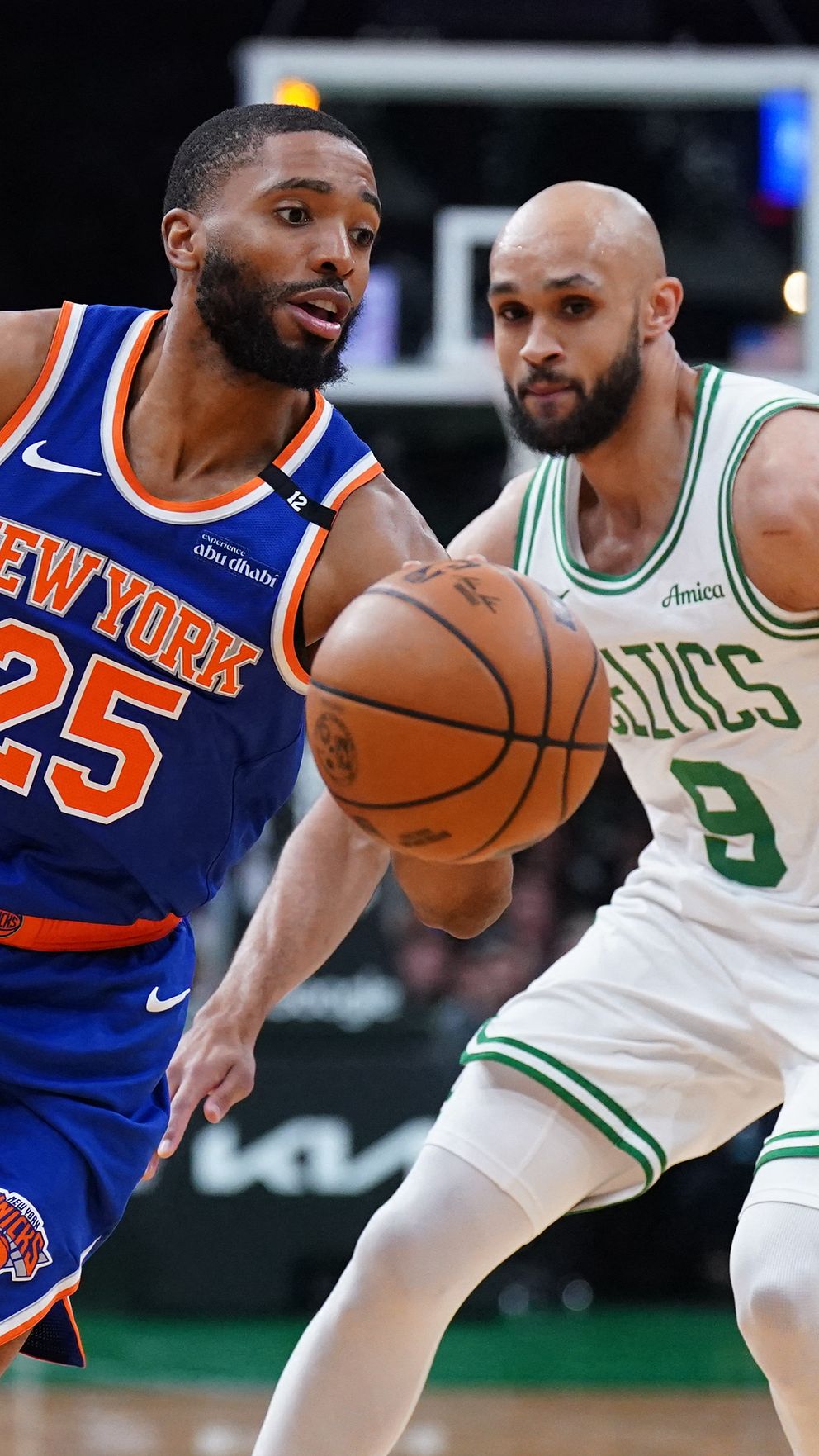 Två basketspelare från Knicks och Celtics kämpar om bollen under match.