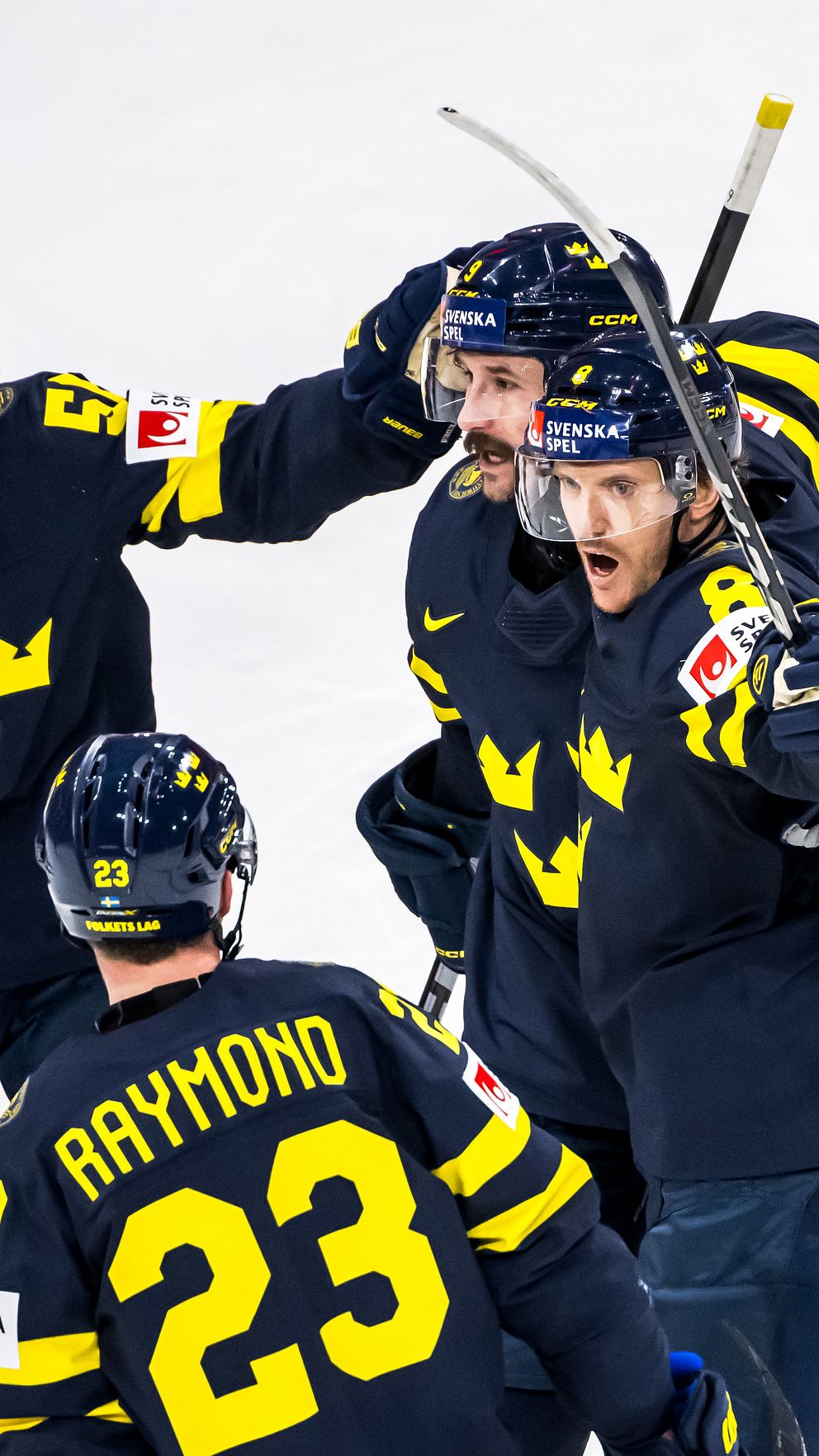 Svenska ishockeyspelare firar tillsammans på isen efter ett mål under match.