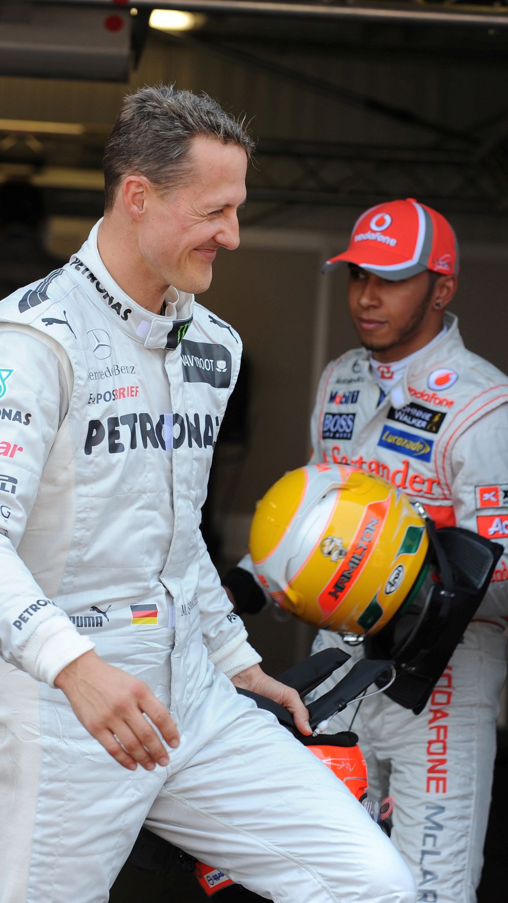 Två Formel 1-förare i depån, klädda i sina respektive teamoverall.