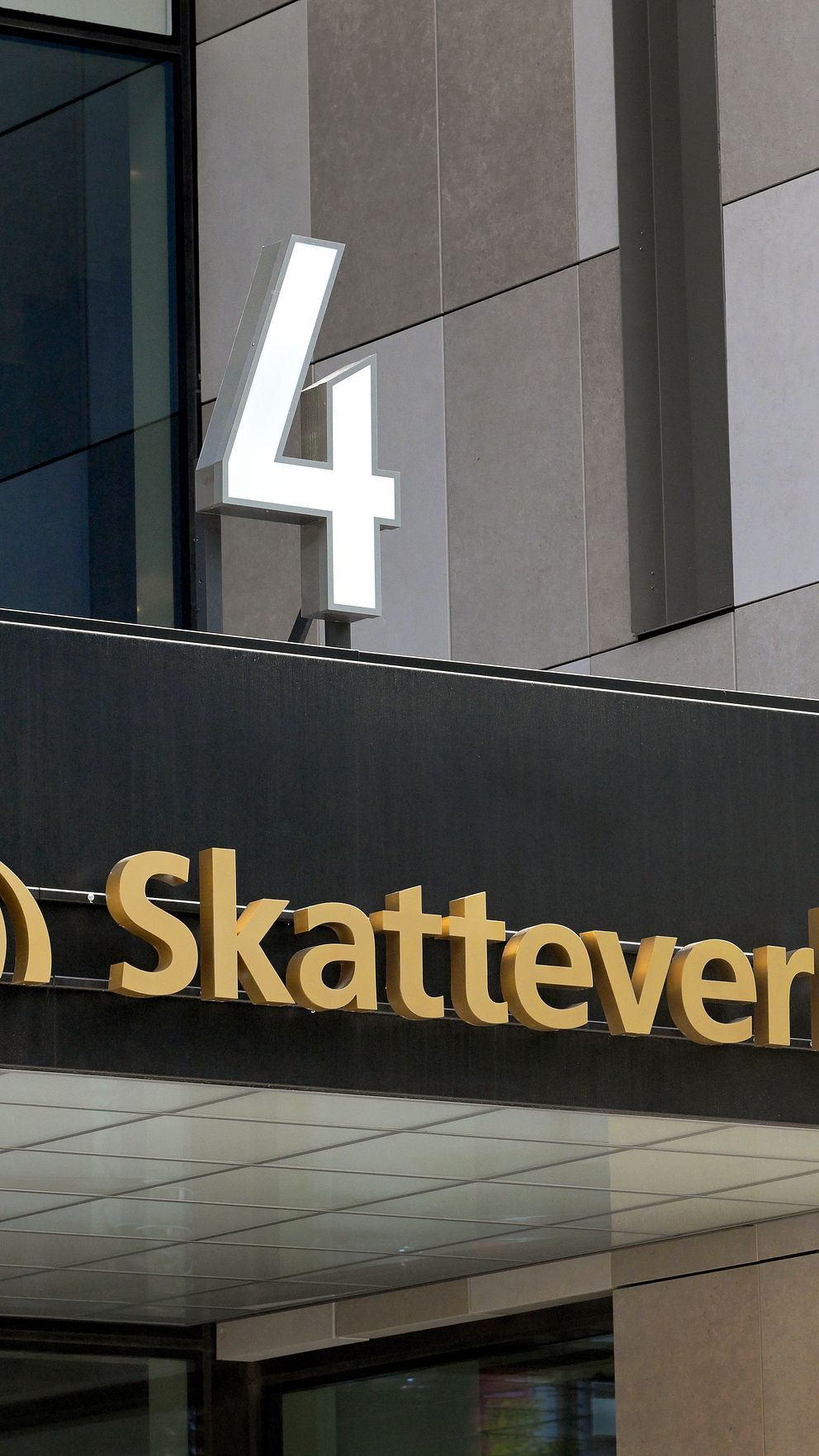 Entré till Skatteverkets kontor med deras logotyp och adressnummer fyra synliga på fasaden.