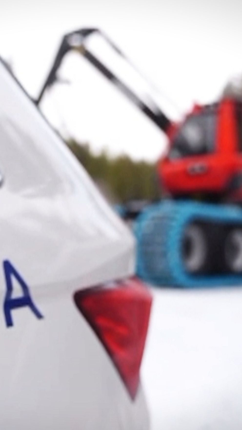 SCA-logotyp på bil med en skogsmaskin i bakgrunden på en snötäckt väg i skogarna kring Backe, i Strömsunds kommun.