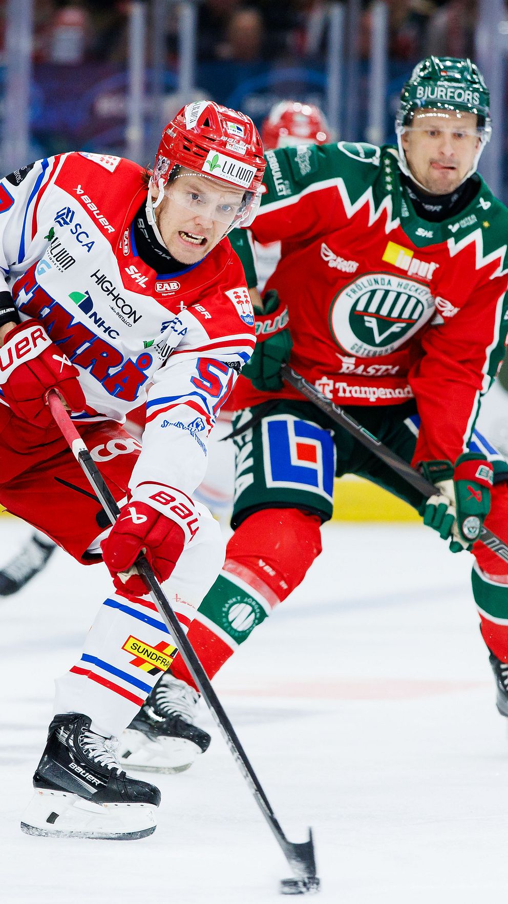Ishockeyspelare tävlar om pucken under en match.