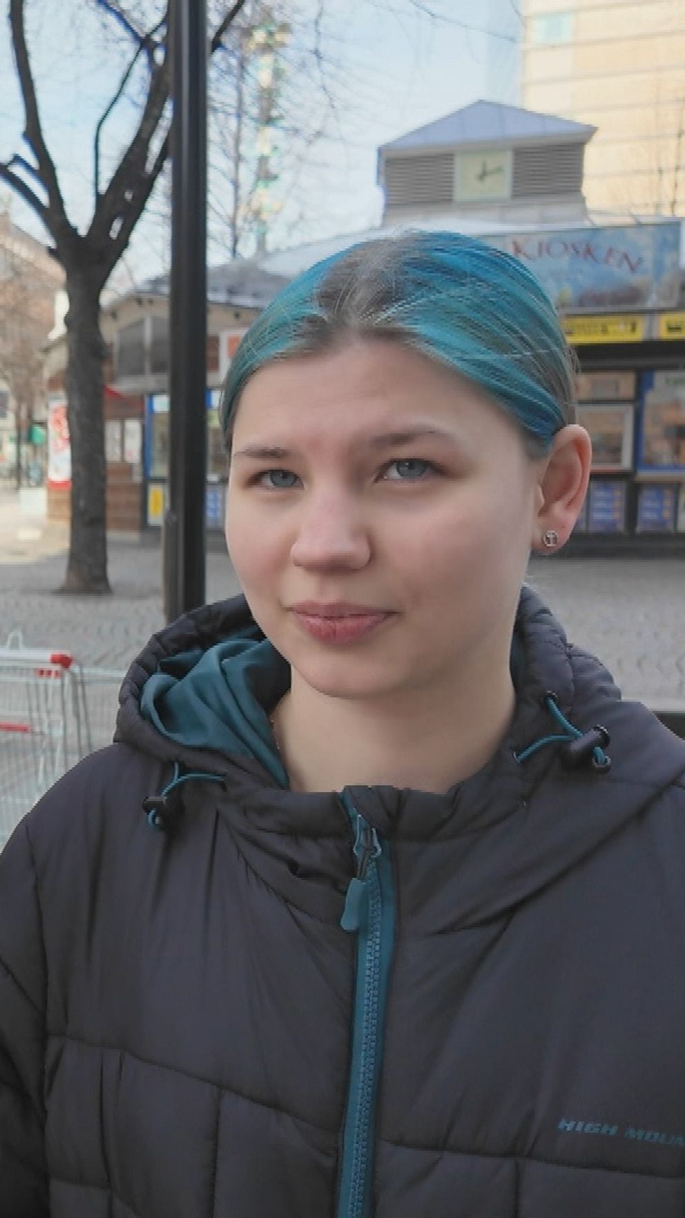 Elin Karlsson och Andrea Arklöf står på stadsgata i Skellefteå med butiker och ett träd i bakgrunden.