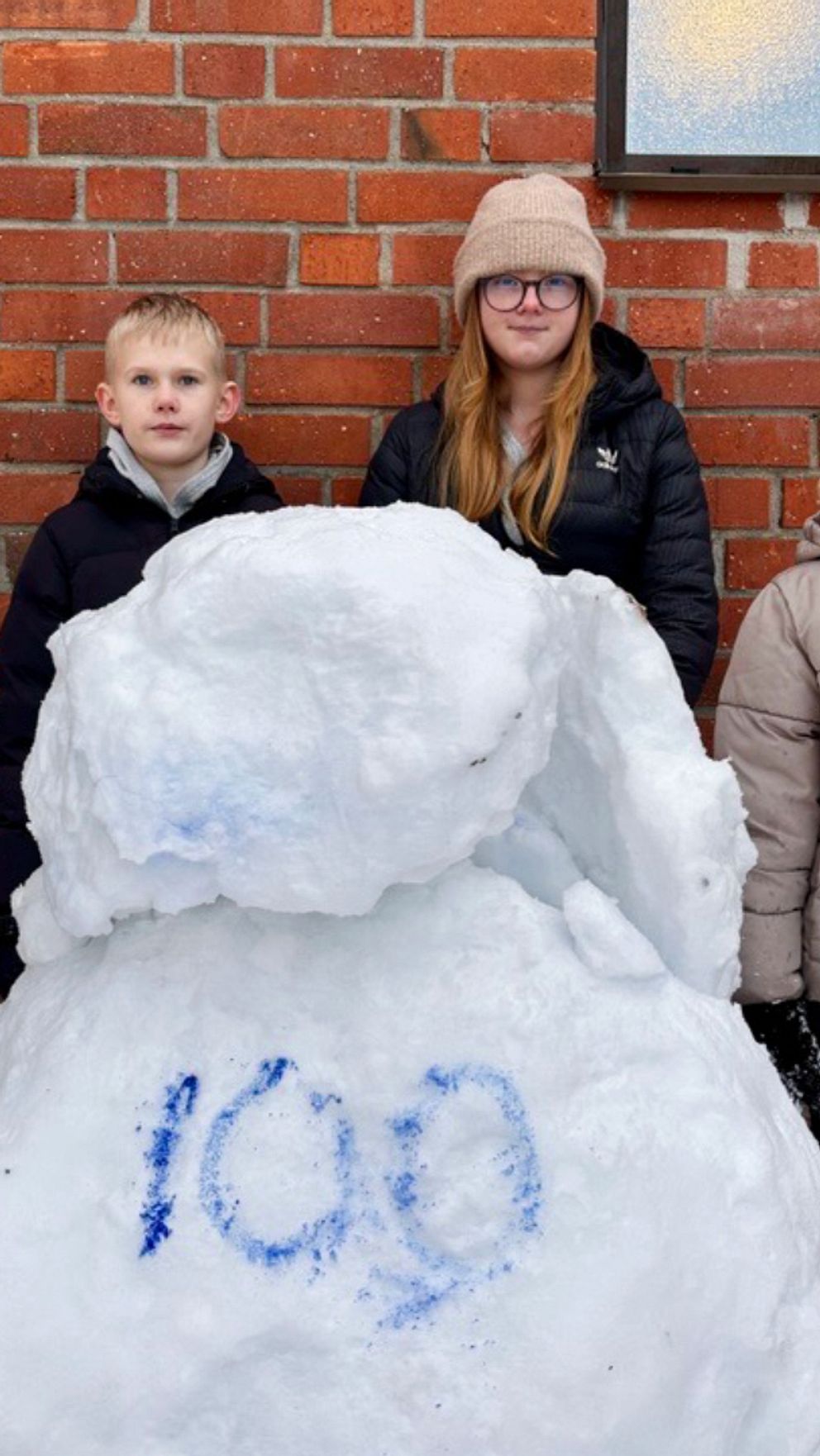 Tvådelad bild: Till vänster syns en snöscen med flera små snögubbar i ett nattbelyst område. Till höger står flera personer vid sidan av en stor snögubbe, där siffran ”100” är skriven med blått på snögubben, framför en tegelvägg.
