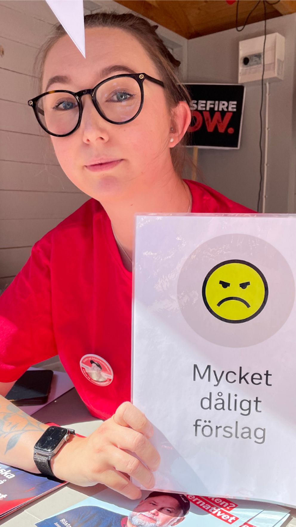 Två politiker, en från Kristdemokraterna och en från Vänsterpartiet som håller upp varsin skylt.