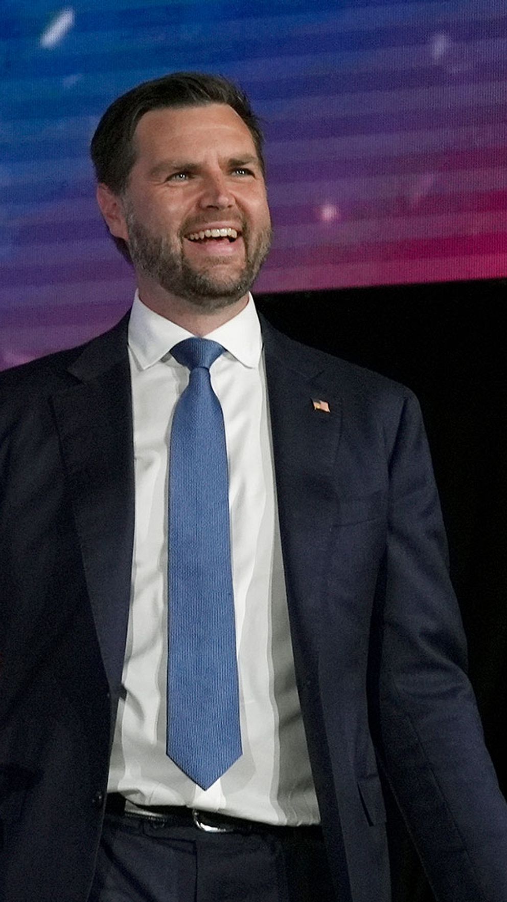 Tvådelad bild på vicepresidentkandidaterna i det amerikanska presidentvalet: Demokraternas Tim Walz och Republikanernas JD Vance. Båda har på sig mörk kostym med blå slips och ler mot en folkmassa.