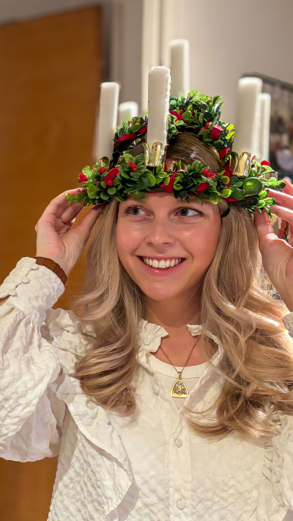 Theres Arvidsson med luciakrona framför en spegel.