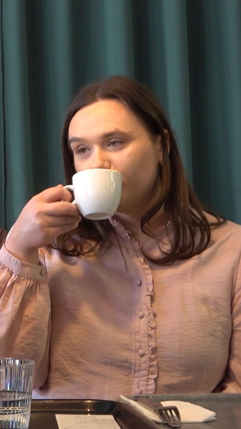 Två personer samtalar och dricker kaffe vid ett kafébord.