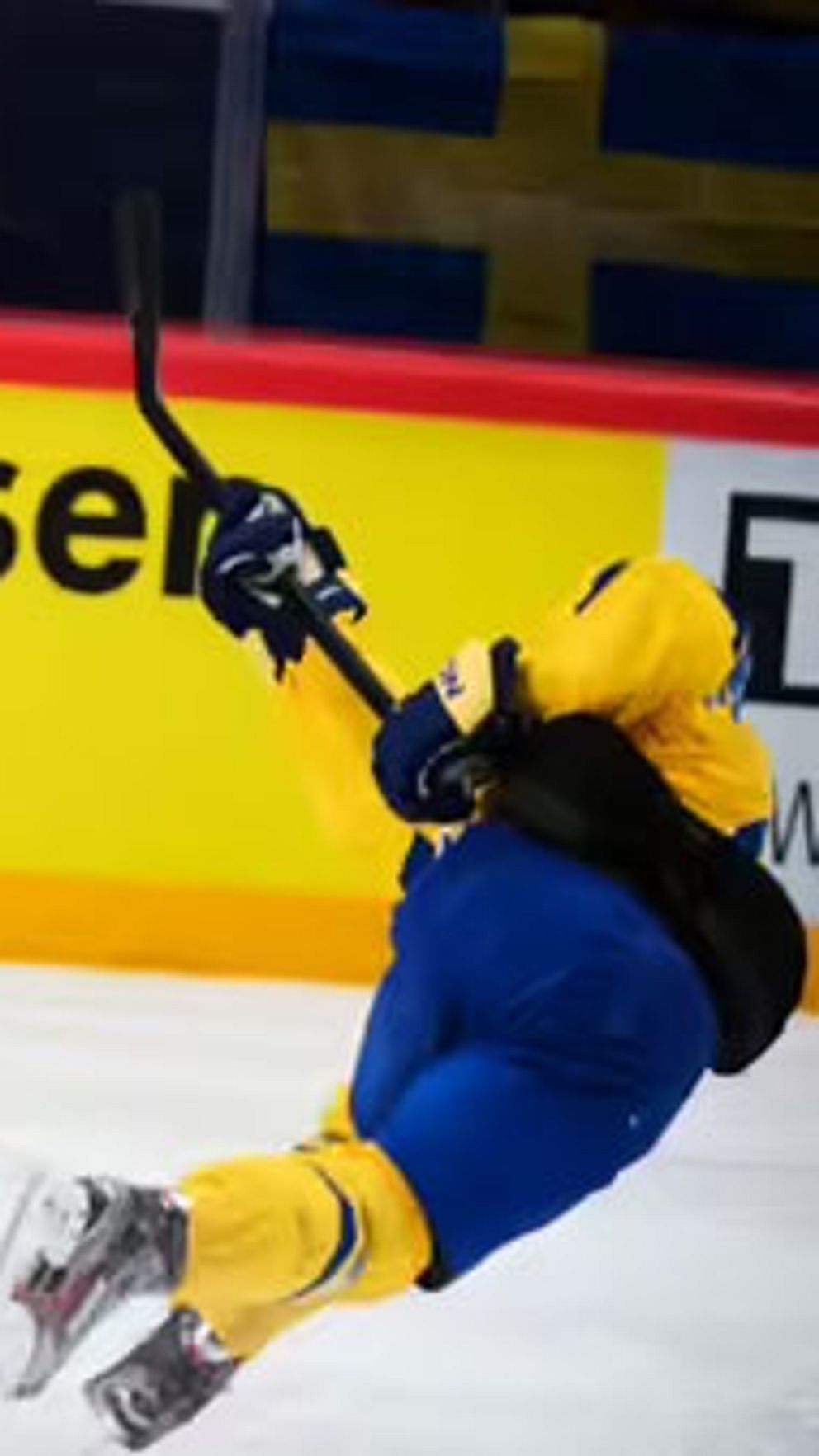 Svensk ishockeyspelare skjuter mot mål, schweizisk målvakt sträcker ut sig för att rädda.