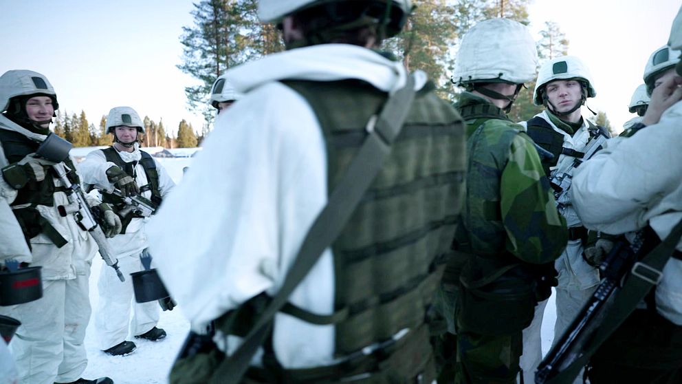 Flera soldater iklädd uniformer med vinterkamouflage.