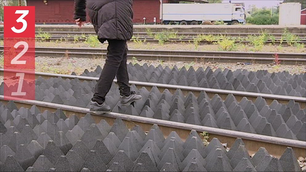 En person som går över ett järnvägsspår. Vid Spåren finns så kallade pyramidmattor som ska försvåra att personer genar över järnvägen