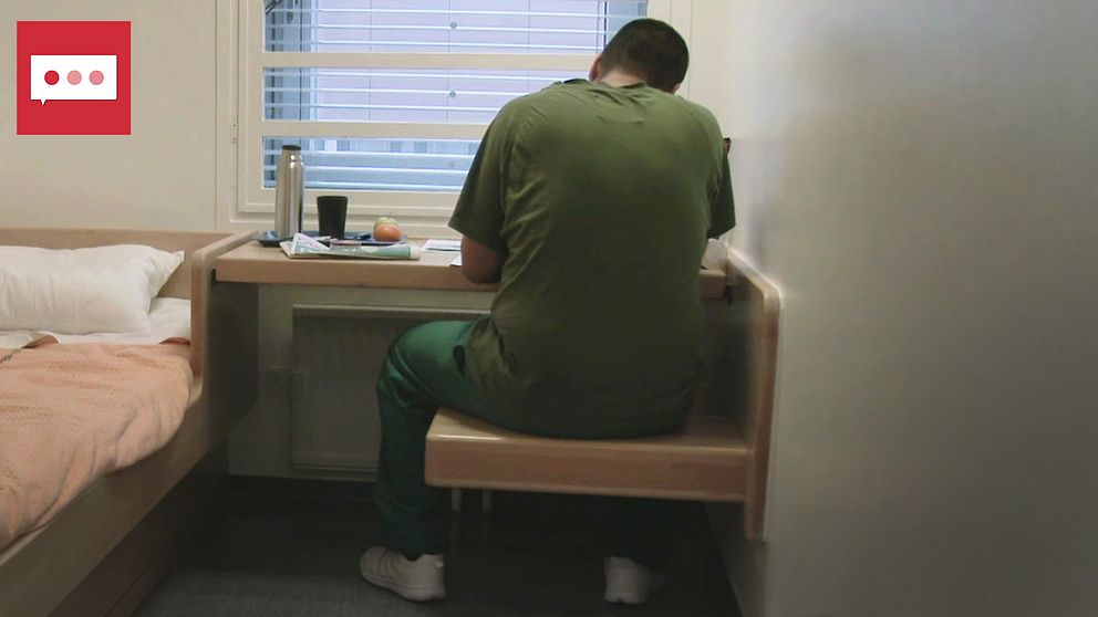 Intern i kriminalvårdens gröna kläder inne i en cell på en anstalt i Sverige