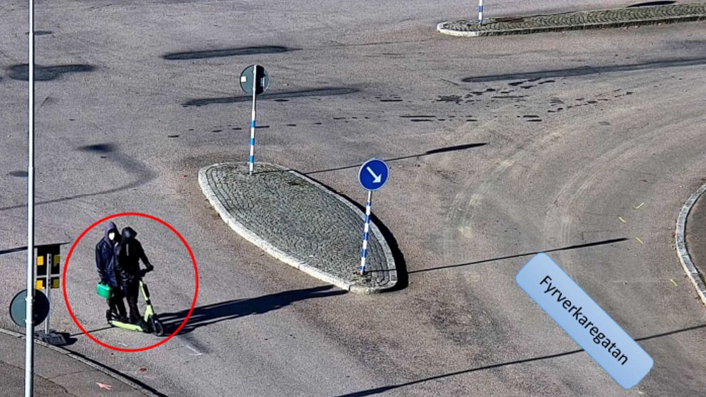 Två maskerade män på en elsparkcykel