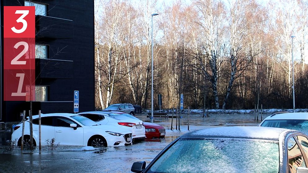 Bilar under vatten och skylt med siffrorna ett, två och tre