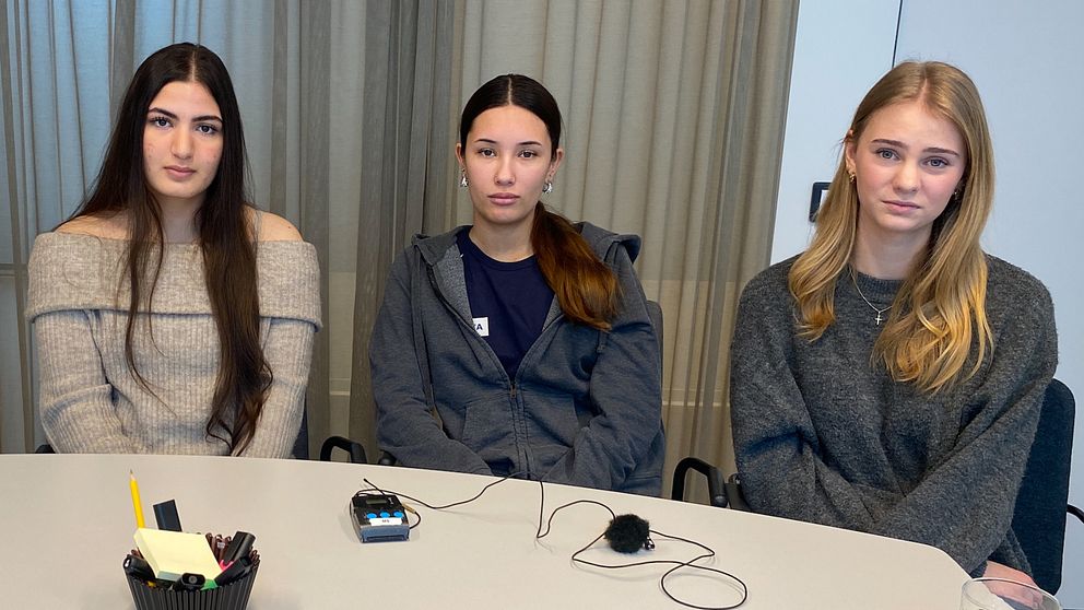 Gymnasietjejerna Nahla Rasheed, Tess Melin och Carolina Karlsson sitter i en sal i Falkenberg.