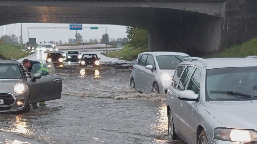 Bilar kör i vatten efter översvämning
