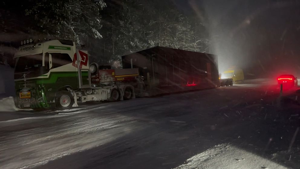 En lastbil står intill vägen i snöoväder