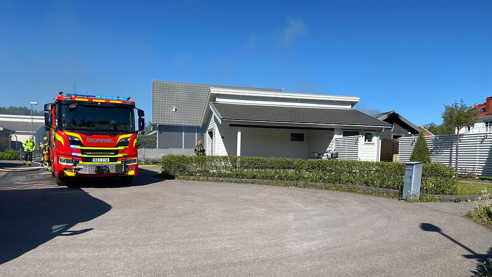 Brandbil som står utanför ett hus.