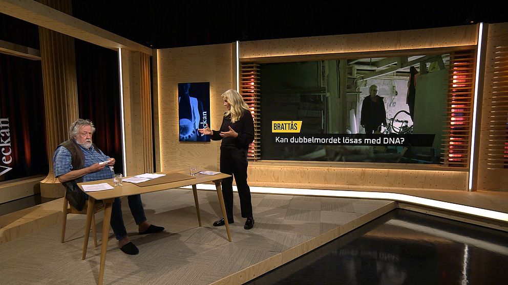 Leif GW Persson sitter och bläddrar i papper i studion, medan Camilla Kvartoft står upp och diskuterar ämnet för programmet Veckan. Skärmen bakom dem visar en bild med texten ”Brattås – Kan dubbelmordet lösas med DNA?”