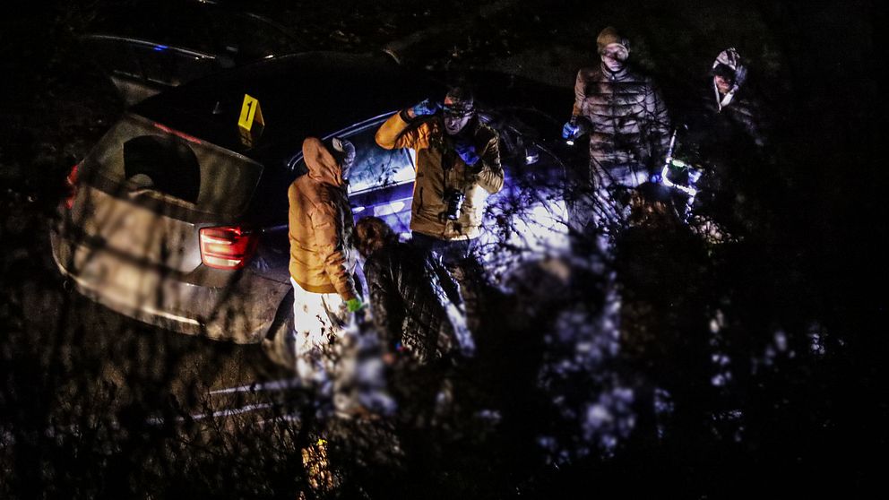 En brottsplatsundersökning i mörkret vid en bil